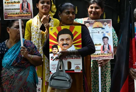 NurPhoto via Getty Images A woman holds a placard at a Dravida Munnetra Kazhagam (DMK) party election campaign in Chennai, India