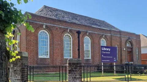 LDRS Charminster Library is a large brick building with high, arched windows.