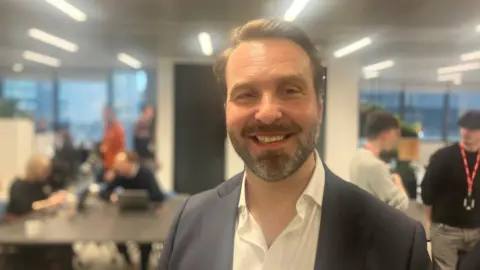Photograph of Leon Butler, the CEO of IBM in the UK and Ireland. He is pictured in an office in Manchester city centre.