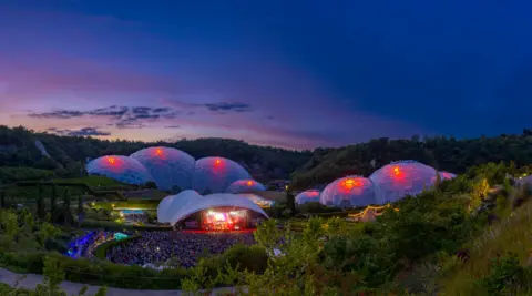 Eden Project The Eden Project in the evening, with a concert at the venue, and the biomes lit up with red ad purple lights, as the sun sets