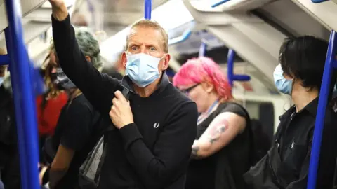 Getty Images Man wearing a face mask on a London Undergrond train