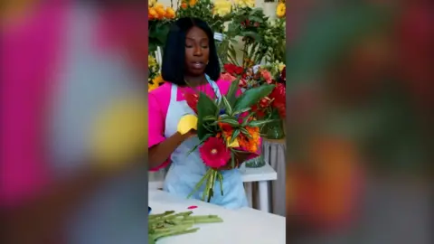 Woman with shoulder-length black hair holding a bunch of flowers
