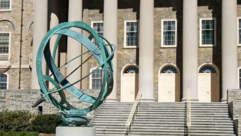 Ametal Sundial on the Penn State University campus with Old Main building behind, a local landmark in State College, Pennsylvania, PA, USA.