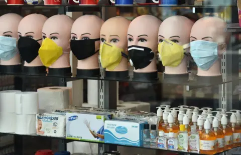 Getty Images In-demand items, including face masks, latex gloves, hand sanitizers, soap and toilet roll are seen on display in a shop window in Brighton, southern England on March 21, 2020