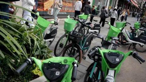 Getty Images Members of the public walk past many Lime rental bikes that are stood on the pavement in Regent Street in September 2023