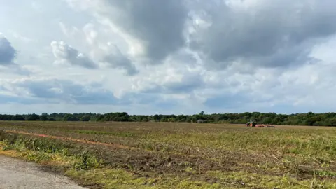 Local Democracy Reporting Service A tractor in a field on the former Wisley Airfield site