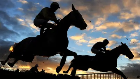 Getty Images Horses jumping over fence