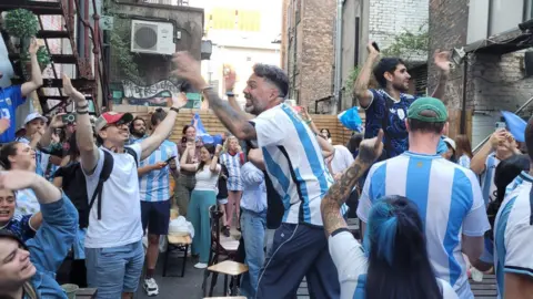 Milton Avila Milton Avila (centre) is in a beer garden with other Argentina fans dancing and cheering to celebrate beating Egypt in the round of 16