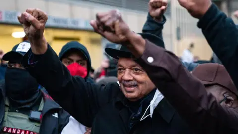 Getty Images Jackson has his fist up in the air, with others at the rally.