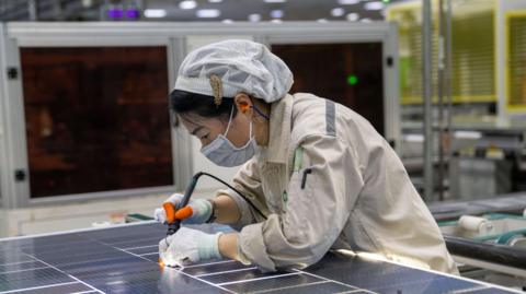 A worker at a photovoltaic module workshop is producing photovoltaic products for export to Europe and India in Hefei, China.