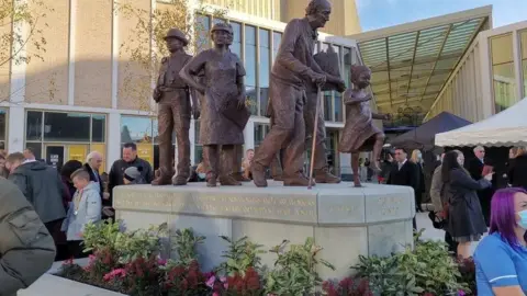 Reverence, a bronze by sculptor Graham Ibbeson, depicts key workers alongside ordinary people affected by the pandemic