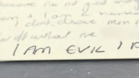 Netflix A handwritten note bearing the words 'I am evil'. 