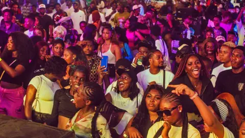 The Plug Entertainment A multitude of young people at the audience looking at the stage of a musical event during Detty December in Lagos, Nigeria, 2024