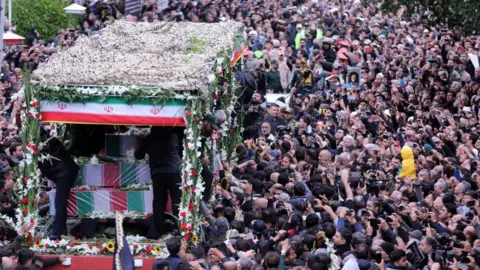 Iranian mourners pay their respects to late president Ebrahim Raisi and his aides during a funeral procession in Tabriz, northwestern Iran
