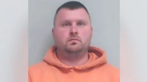 Police Scotland A police mugshot of Yuen Lawson looking at the camera, he is wearing an orange hoodie.