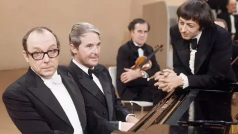 Still from Morecambe and Wise's celebrated Christmas Show sketch where conductor Andre Previn (far right) 