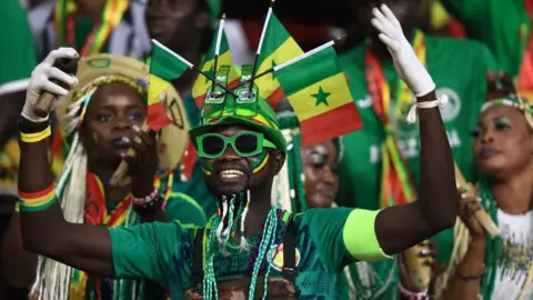 AFP Senegal's supporters cheer during the Africa Cup of Nations (CAN) 2021 final football match between Senegal and Egypt at Stade d'Olembe in Yaounde on February 6, 2022