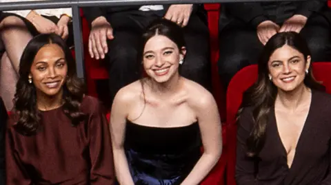 AMPAS Zoe Saldaña, Mikey Madison and Monica Barbaro in the 97th Oscars nominees dinner class photo