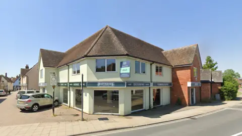 Google Maps A light green building in High Street, Hadleigh with cars parked nearby.