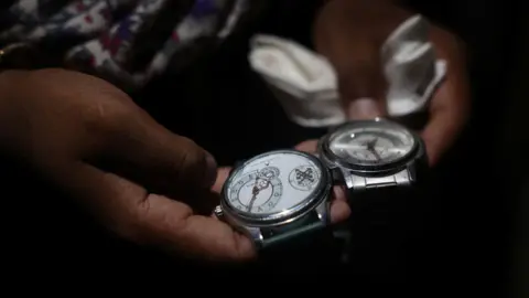 Reuters Babita Kumari, sister of Pradeep Kumar, 22, an aspirant doctor who took his own life after the results of the first NEET exam were cancelled, shows watches that Pradeep loved to wear, at her home in Jhunjhunu, India, July 21, 2026. REUTERS/Francis Mascarenhas
