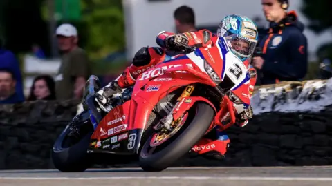 IOM TT Dean Harrison on his machine which is in the Honda team colours of red white and blue.