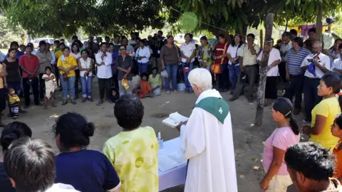 AFP/Getty Images A Catholic priests officiates a mass in north-eastern Bolivia. File photo