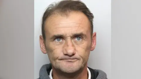 NCA Police mugshot of Fernando Fuster looking at camera, wearing a grey jacket