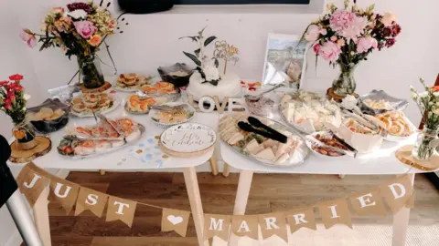 EKR Pictures A table with a 'just married' sign and lots of plates of food