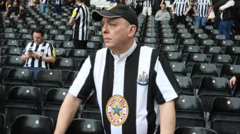 A man in a Newcastle black and white shirt
