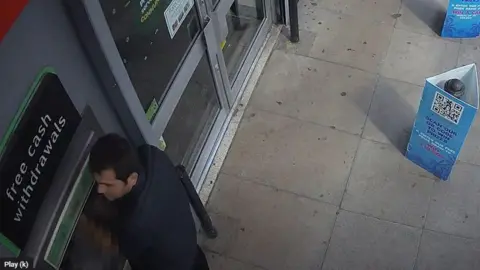 YHROCU A man tampering with a cash machine seen on CCTV.