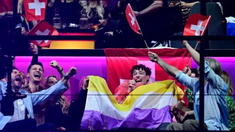 AFP Switzerland's Eurovision winner Nemo and supporters celebrate with non-binary flag