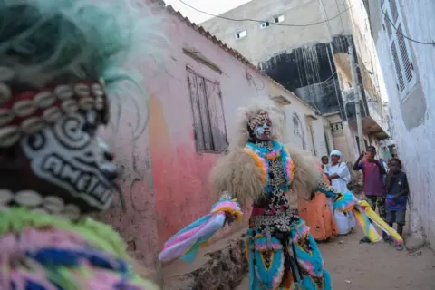 RICCI SHRYOCK / AFP  A performer dances in a traditional Simb costume during a cultural show at Ngor in Dakar, on August 12, 2024. The Simbs perform dances and rituals throughout the year in Senegal for various occasions, such as Independence Day, summer school break, wrestling matches and more. (Photo by RICCI SHRYOCK / AFP) (Photo by 