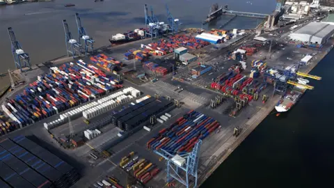 An aerial image showing colourful containers, blue cranes and freight ships at the Port of Tilbury, which sits on the banks of the River Thames.