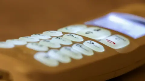 Getty Images A modern white phone with lit-up buttons.