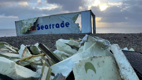 George Carden/BBC A container in Selsey which is torn up with holes in it, and there is insulation piled up on the floor