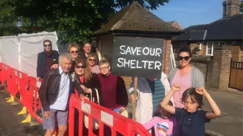 Residents of Caddington protest against the planned demolition of their village bus stop.