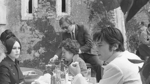 Getty Images Alain Delon, Brigitte Bardot and the film crew in a lunch break during the shooting of Spirits of the Dead in Rome 1967