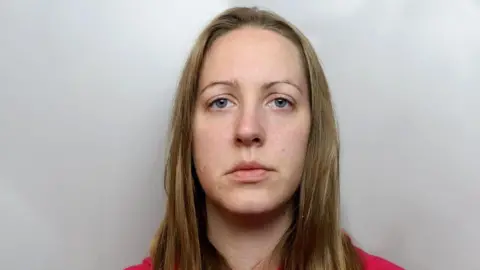 Mugshot of Lucy Letby, who has shoulder-length straight blonde hair and wears a pink top.