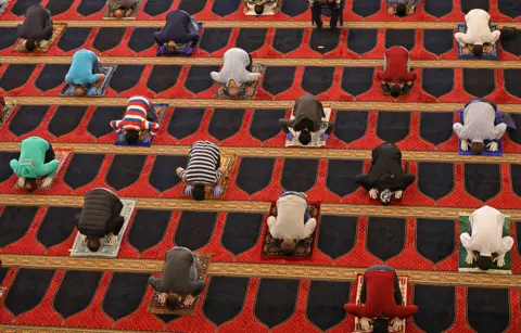 Getty Images Worshippers pray whilst social distancing