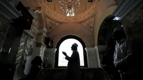 DINUKA LIYANAWATTE A Muslim priest prays during Eid al-Fitr to mark the end of the holy fasting month of Ramadan at Dewatagaha Mosque in Colombo, Sri Lanka on 24 May 2020