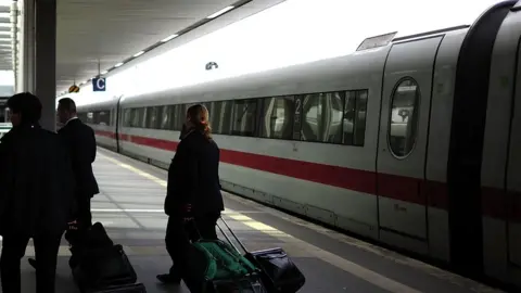 Getty Images Rail personnel walk by a high-speed train in Hannover, Germany. Photo: May 2015