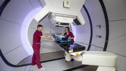 PA Radiographers David Kirk and Melissa Bentley with a test dummy as they demonstrates the new Proton Beam therapy centre at The Christie hospital in Manchester.