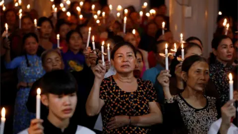 Reuters Worshippers with candles