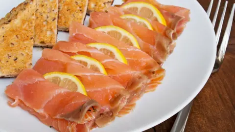 Getty Images Smoked salmon and lemon on a plate with toast