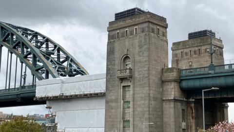 View of the Tyne Bridge from Gateshead showing scaffolding and Kittiwake hotels on top of tower