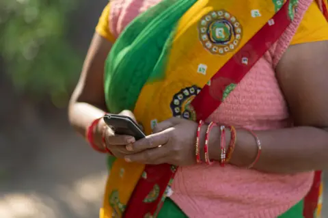 Getty Images Closeup of the Hand of a house maid Using a Mobile Phone 