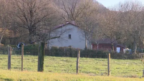 France Winter Year is a home with white walls surrounded by trees and hedges