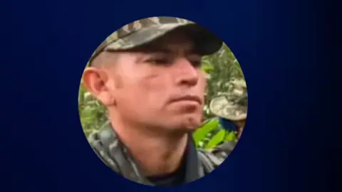 A screengrab from a video shared by Colombian President Abelardo de la Espriella shows a photo of Hernando Forero Mosquera, aka "El Ruso", accused of being a leader of a dissident Farc rebel faction. He is wearing a cap in camouflage colours and a shirt, also in camouflage colours. 