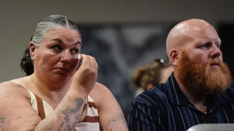 PA Media Natalie and David Needham sat in the audience at the press conference for the publication of the Ockenden review