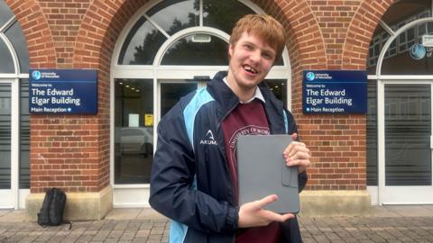 Christian Wilson smiling while holding an iPad